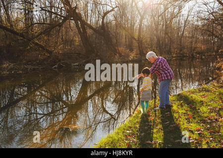Großmutter zeigt am Fluss mit ihrer Enkelin Stockfoto