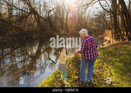 Großmutter, die Hand in Hand mit ihrer Enkelin Fluss Stockfoto