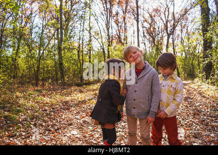 Drei glückliche Kinder spielen im Wald Stockfoto