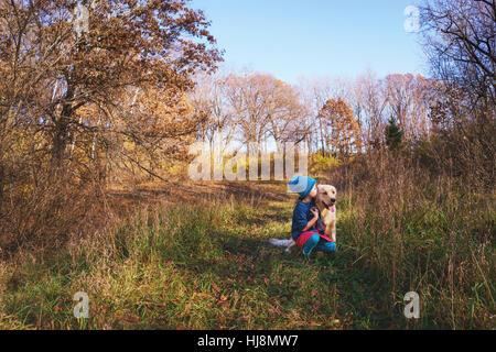 Mädchen küssen ihr golden Retriever Welpen Hund Stockfoto