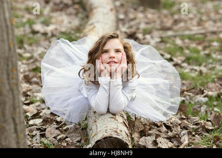 Mädchen tragen eine Tutu Kleid auf einem Baumstamm liegend Stockfoto