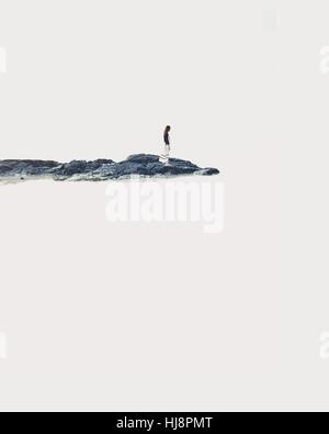 Frau auf Felsen am Meer Stockfoto