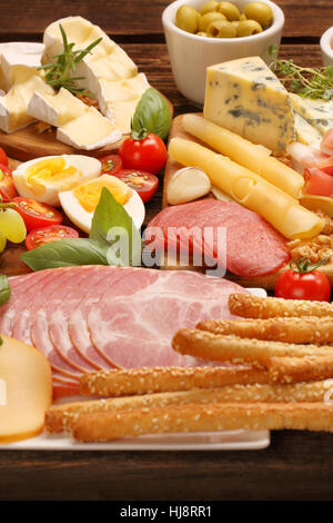 Buffet mit verschiedenen Arten von Käse und Vorspeisen auf rustikalem Holzbrett legen Stockfoto