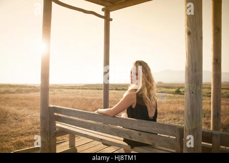 Mädchen sitzen auf einer Bank, Tarifa, Cádiz, Andalusien, Spanien Stockfoto