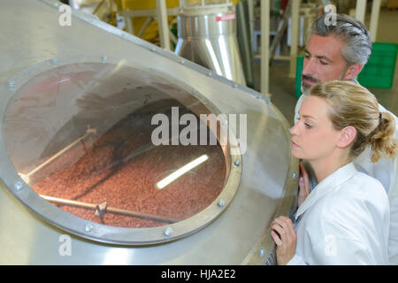 Mann und Frau auf der Suche durch Bullauge der Mehrwertsteuer Stockfoto