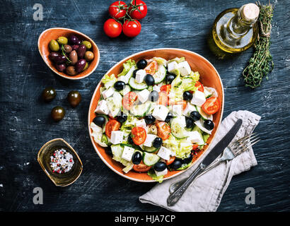 Griechischer Salat mit frischem Gemüse, Schafskäse und schwarzen Oliven auf schwarzem Hintergrund, Ansicht von oben mit Textfreiraum Stockfoto