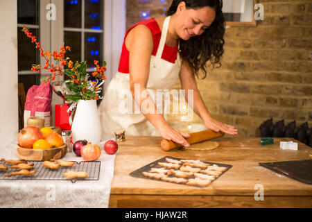 Reife Frau Rollen Christmas Cookie Gebäck am Küchentisch Stockfoto