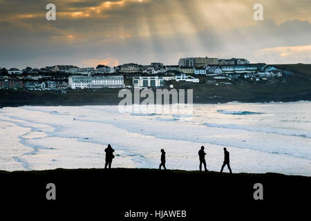 Menschen in der Silhouette zu sehen, wie sie Fuß entlang der Küste mit Blick auf Fistral Beach in Cornwall, England, UK. Stockfoto