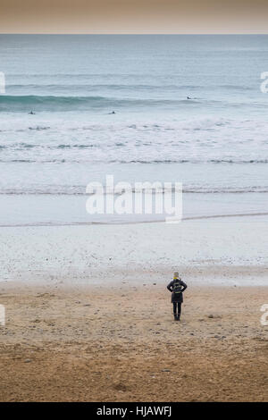 Eine Frau allein auf Fistral Strand in Newquay, Cornwall, England, UK. Stockfoto