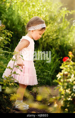 Entzückende kleine Mädchen, die einen schönen Garten zu erkunden Stockfoto