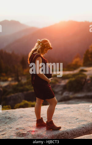 Schwangere Frau in Bergen berühren Magen, Sequoia Nationalpark, Kalifornien, USA Stockfoto