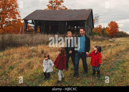 Mitte Erwachsene Familie mit drei Töchtern Hand in Hand und einen Spaziergang im ländlichen Bereich Stockfoto