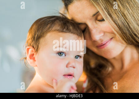 Mutter Augen schließen, Kleinkind kuscheln Stockfoto