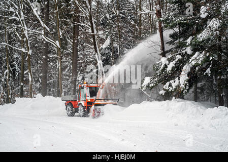 Halter C9700H kommunaler Traktor mit Schneefräse Schneeräumung von Straße im Wald nach starkem Schneefall im winter Stockfoto