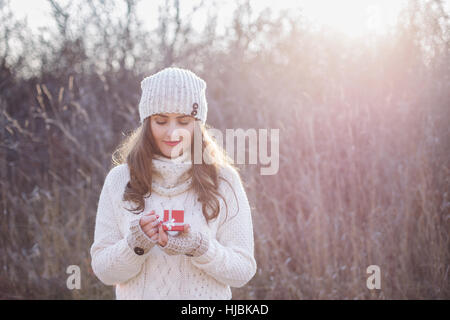 Junge Frau ein Valentinstag Geschenk in ihren Händen hält Stockfoto