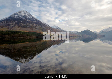 Berge, Felsen und Bäume spiegelt sich in der ruhigen Oberfläche von Crummock Wasser, Keswick, Cumbria, Lake District, England UK. Stockfoto