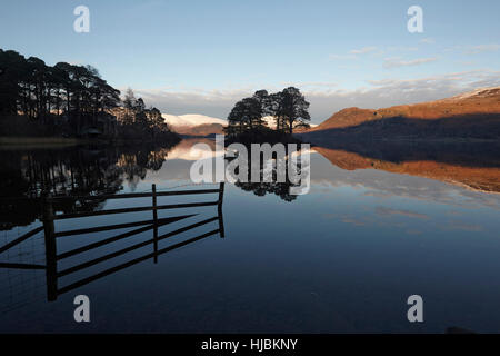 Abendlicht der Sonne fängt die schneebedeckten Hänge des Skiddaw und Blencathra spiegelt sich in Derwent Wasser Seenplatte, Cumbria Stockfoto