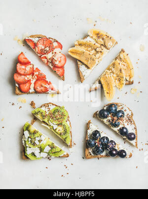 Gesundes Frühstück Vollkorn Toast mit Frischkäse, Früchte, Samen, Nüssen Stockfoto