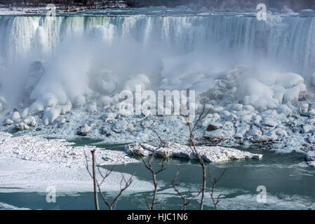 Ein Nebel steigt aus den gefrorenen Schnee bedeckten Felsen unterhalb der Niagarafälle. Stockfoto