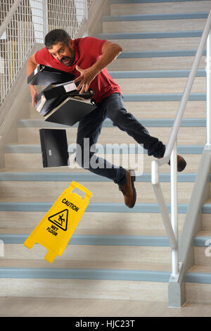 Hispanische Arbeiter tragen Dateien fallen auf nassen Treppen Stockfoto