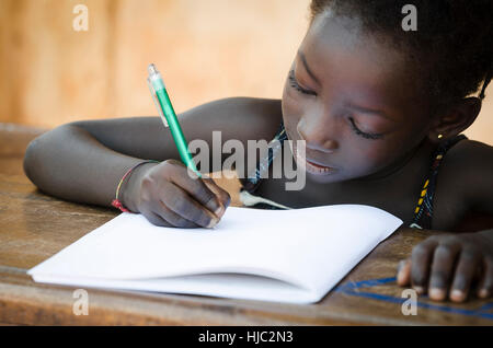 Schulbildung Symbol - afrikanische Mädchen schreiben Notizen (echte Menschen) Stockfoto