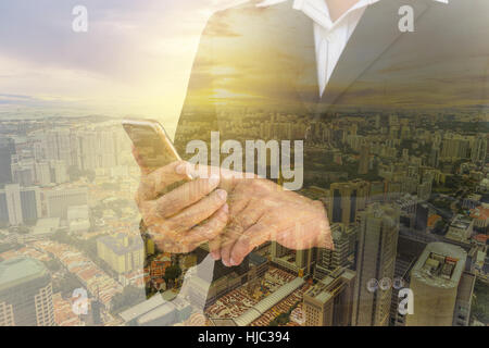 Doppelbelichtung Geschäftsmannes zu überprüfen sein Smartphone und Stadtbild und Sonne Licht filter - können anzeigen oder montage auf Produkt Stockfoto