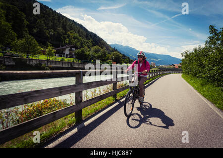 Weibliche Radfahrer Rad Weg vom Fluss im Vinschgau-Tal, Südtirol, Italien Stockfoto