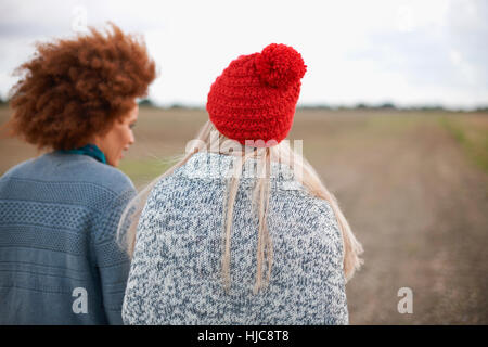 Rückansicht der beiden jungen Frauen, die einen Spaziergang im Feld Stockfoto