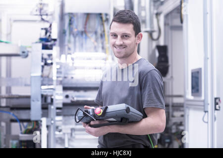 Porträt von Ingenieur mit elektronische Vorschaltgeräte in Maschinenfabrik Stockfoto