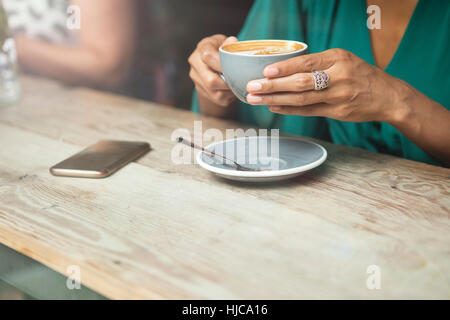 Frauenhand Kaffeetasse im Café Fenster halten Stockfoto