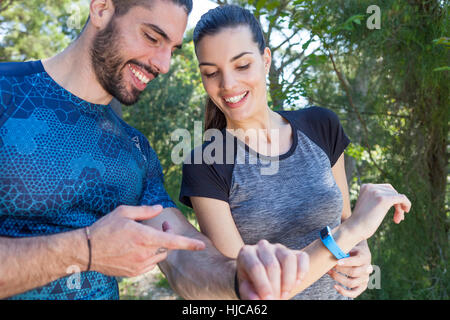 Männliche und weibliche Läufer Check-Smartwatches im Park, Split, Dalmatien, Kroatien Stockfoto