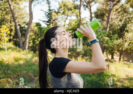 Weibliche Läufer Trinkwasser Flasche im Park, Split, Dalmatien, Kroatien Stockfoto