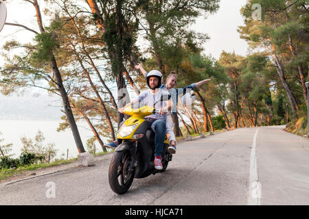 Paare Reiten Moped auf Landstraße, Split, Dalmatien, Kroatien Stockfoto