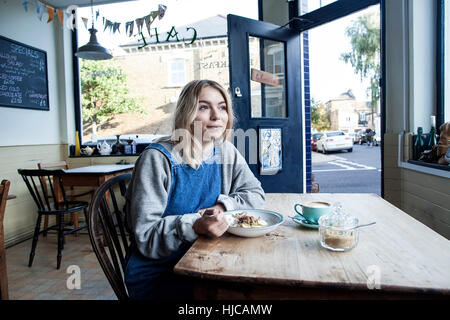 Junge Frau in Café, essen Müsli Stockfoto
