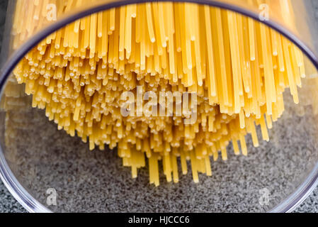 Trocken und ungekochte Spaghetti in transparenten Kunststoff Kanister. Stockfoto