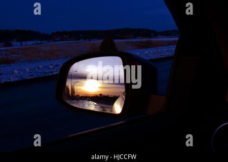 Sonnenuntergang in Auto Seitenansicht Spiegel reflektiert. Stockfoto