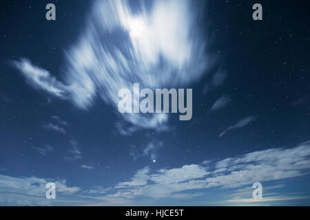 Nachtaufnahme von abgestuften dunkelblauen Himmel mit Sternen und bewegende Wolke Abdeckung Licht vom Mond in der Wintersaison. Stockfoto