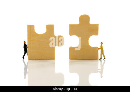 Miniatur-Menschen, die das Puzzle-Problem zu lösen Stockfoto