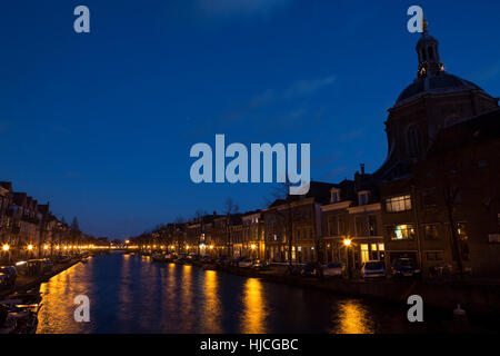 Nacht-Blick auf einen Kanal in der niederländischen Universität Stadt Leiden. Blaue Stunde auf einen Winter-Abend mit Reflexionen in das Stille Wasser Stockfoto