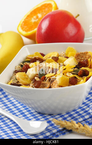 Schüssel mit Haferflocken und Obst auf kariertem Geschirrtuch - Nahaufnahme Stockfoto