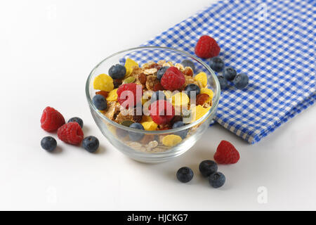 Schüssel mit Getreide und Beerenfrucht und karierte Serviette Stockfoto