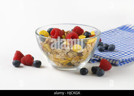 Schüssel mit Getreide und Beerenfrucht und karierte Serviette Stockfoto