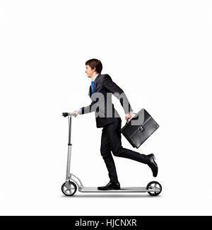 Bild der junge Geschäftsmann im schwarzen Anzug fahren Roller Stockfoto