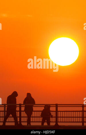 Sonnenuntergang über Southport, Merseyside. Großbritannien Wetter: 23. Januar 2017.  Als die Sonne schließlich bricht durch den eiskalten Nebel über Southport löschen, Menschen genießen den letzten von der Sonne durch einen Spaziergang hinunter Southport des berühmten viktorianischen Pier. Bildnachweis: Cernan Elias/Alamy Live-Nachrichten Stockfoto