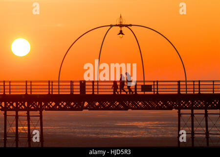 Sonnenuntergang über Southport, Merseyside. Großbritannien Wetter: 23. Januar 2017.  Als die Sonne schließlich bricht durch den eiskalten Nebel über Southport löschen, Menschen genießen den letzten von der Sonne durch einen Spaziergang hinunter Southport des berühmten viktorianischen Pier. Bildnachweis: Cernan Elias/Alamy Live-Nachrichten Stockfoto