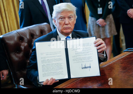 Washington, USA. 24. Januar 2017. US-Präsident Donald Trump zeigt eine der fünf Ausführungsverordnungen unterzeichnete im Zusammenhang mit der Öl-Pipeline-Industrie im Oval Office des weißen Hauses in Washington, DC, USA. Bildnachweis: Shawn Thew/Pool über CNP MediaPunch Inc/Alamy Live-Nachrichten Stockfoto