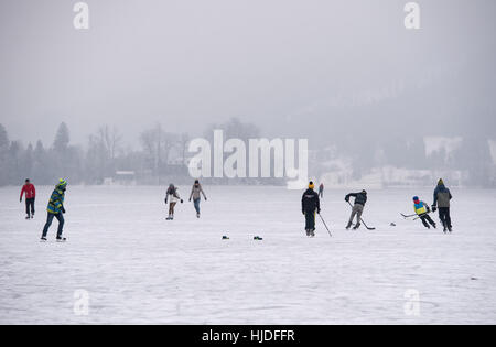 Menschen Sie Skate auf der gefrorenen Oberfläche von Schliersee, Deutschland, 24. Januar 2017. Jungen sind Eishockey spielen. Foto: Sven Hoppe/dpa Stockfoto