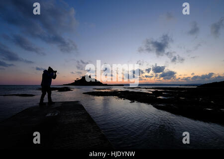 Dramatische stimmungsvolle Foto der St.Michaels Berg und Silhouette des Fotografen in der Abenddämmerung Marazion Stockfoto