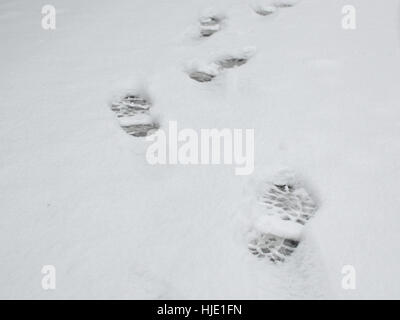 Drucke von Schuhen auf einer Straße mit nur gefallene Schnee bedeckt Stockfoto