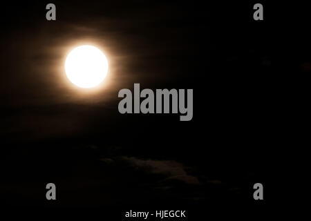 Super helle Vollmond und teilweise mit dramatischen schwarzen Himmel Wolken bedeckt. Stockfoto